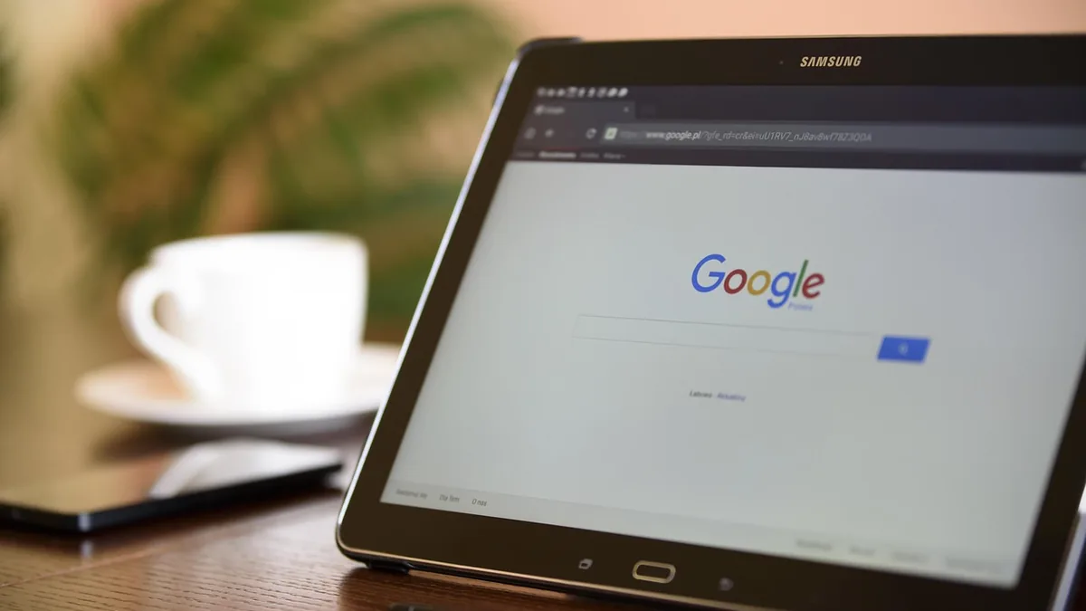 Masadaki tablette açık arama motoru ve yanında kahve fincanı