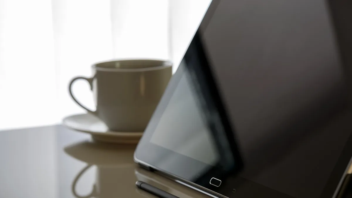 Masa başında tablet ve dizüstü bilgisayarla çalışan yönetici
