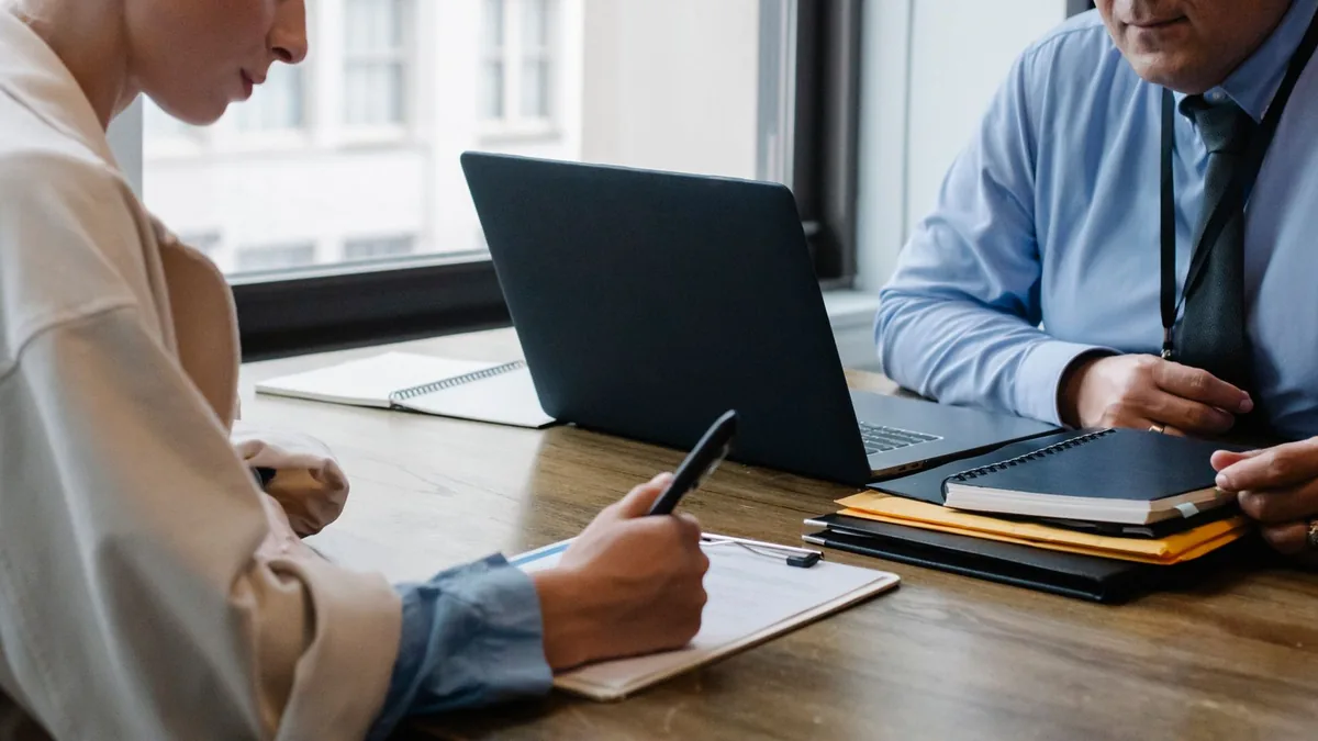 Ofis masasında belge imzalayan iş ortakları
