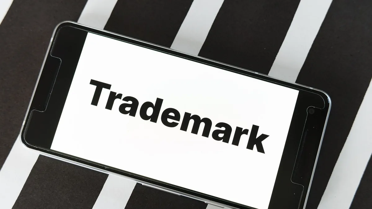 Ekranında Trademark yazan telefonun üstten görünümü