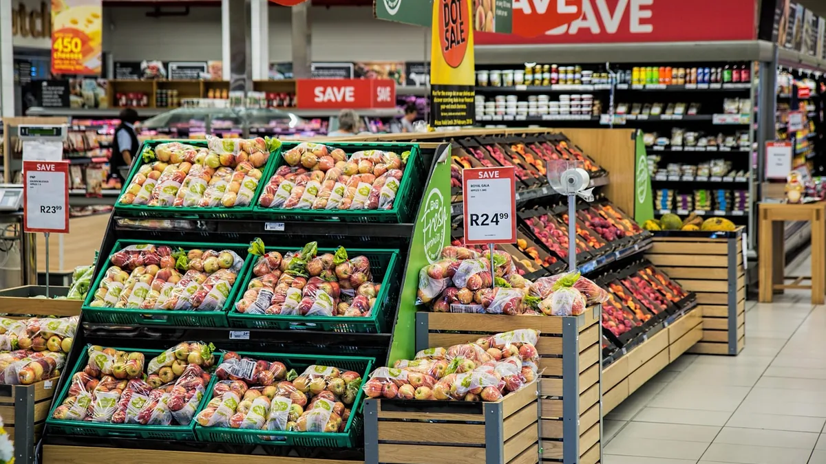 Fiyat tabelaları ve ürün kasaları bulunan market reyonu