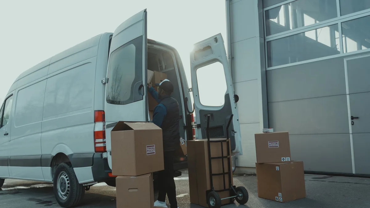 Teslimat aracından paketleri alan görevli