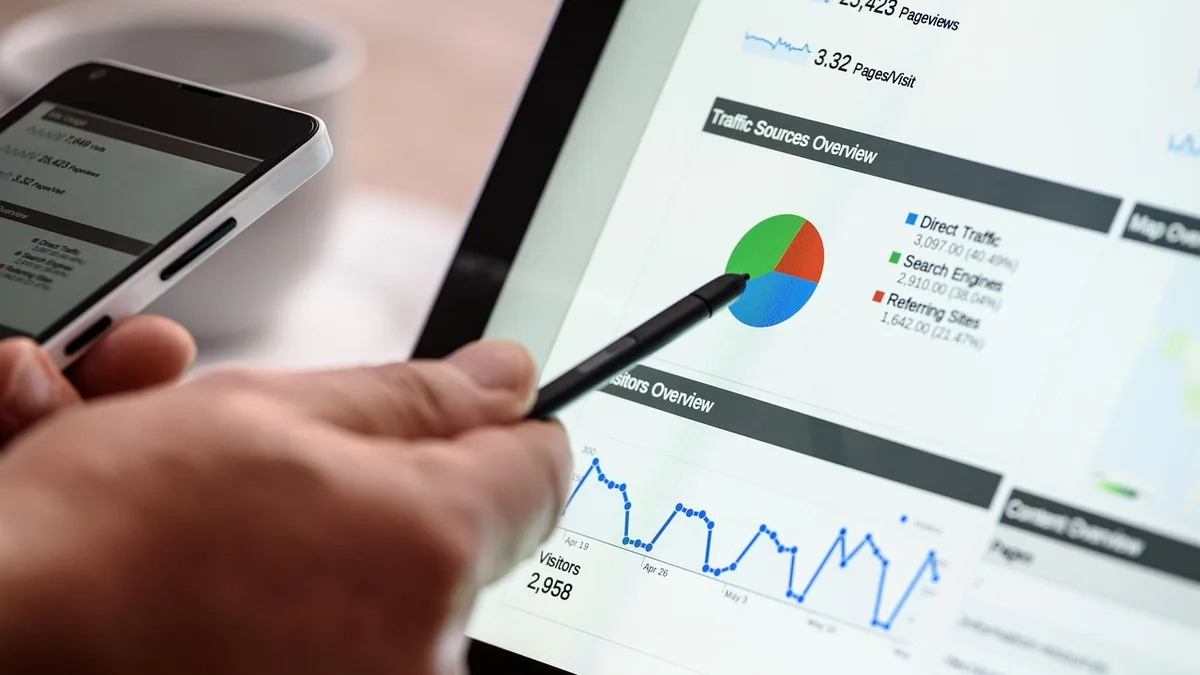Tablet ekranındaki trafik grafiklerini kalemle inceleyen kişi