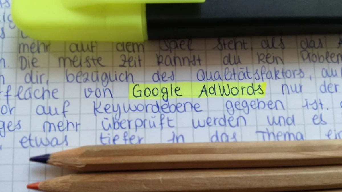 Reklam ve anahtar kelime notlarının işaretlendiği defter ile kalemler