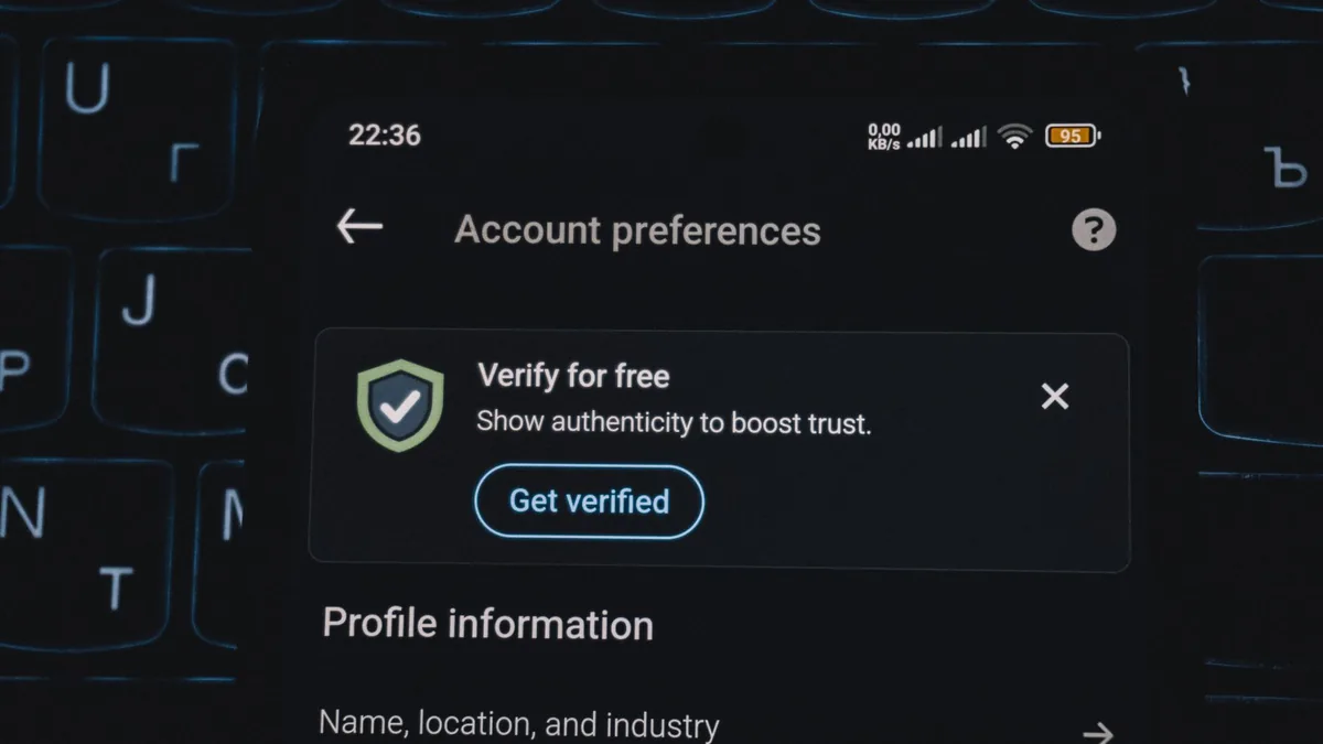 Dizüstü bilgisayar önünde hesap doğrulama ekranı açık telefon