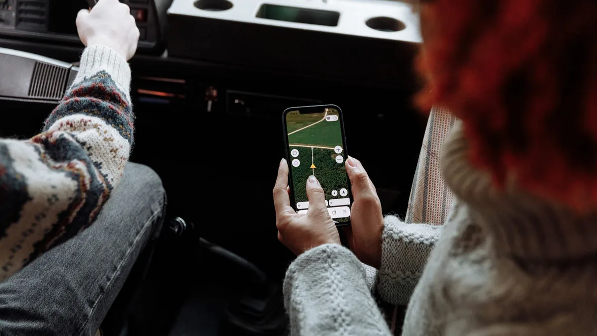 Araç içinde telefondaki dijital haritayı inceleyen yolcu