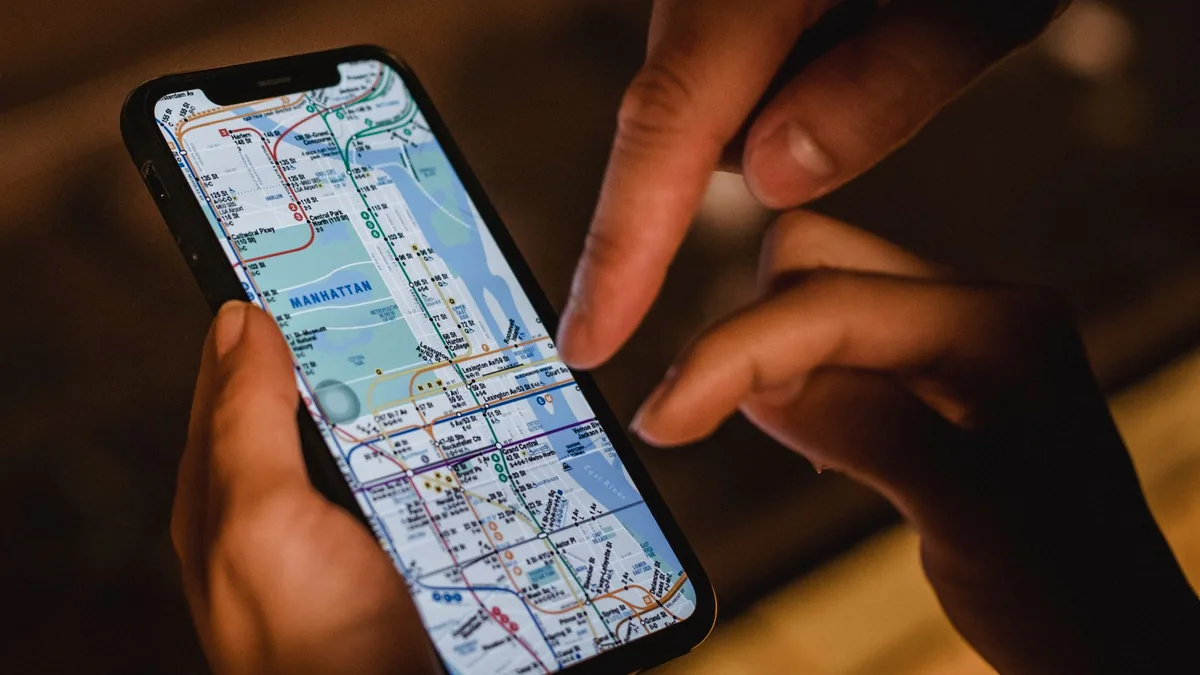 Şehir sokağında telefondaki haritaya birlikte bakan iki kişi