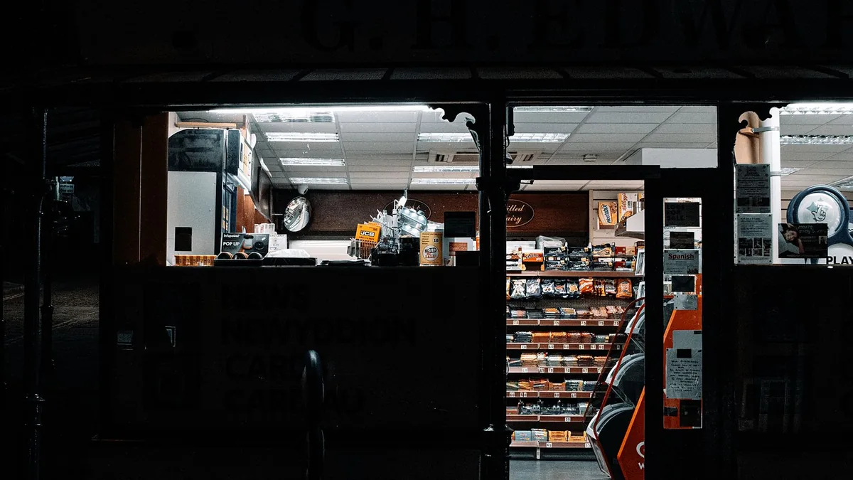 Gece açık ve aydınlık bir mahalle marketinin dış görünümü