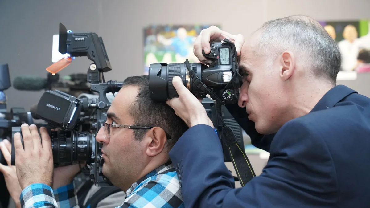 Bir etkinlikte yan yana görüntü çeken basın fotoğrafçıları