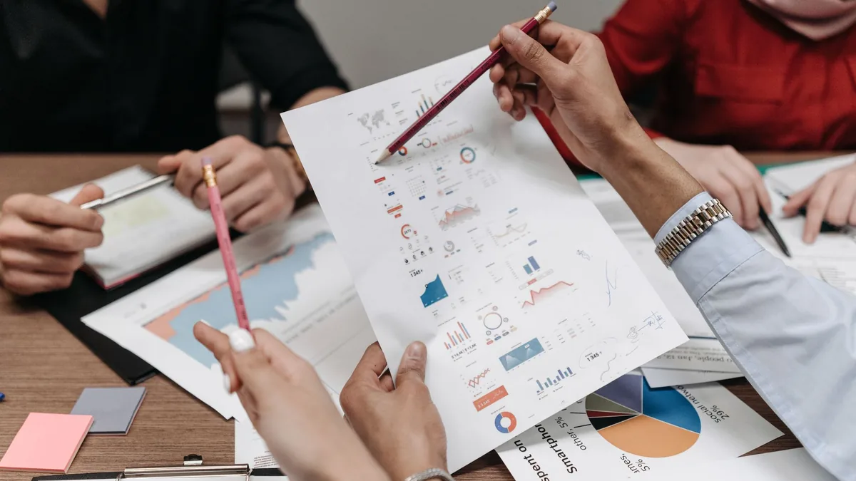 Basılı grafik ve notları birlikte inceleyen çalışma ekibi