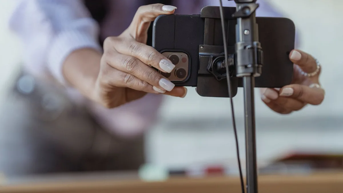 Tripoda yerleştirdiği telefonla dikey video hazırlayan kadın