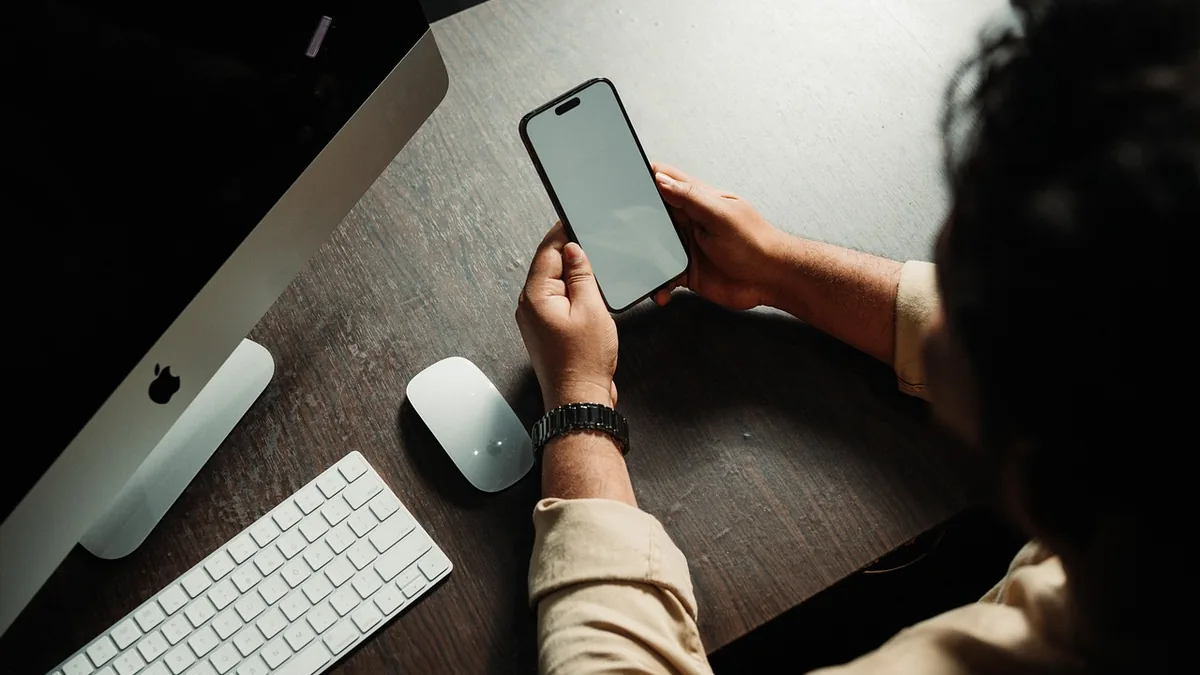 Akıllı telefon ekranındaki sosyal medya içeriğini inceleyen kişi