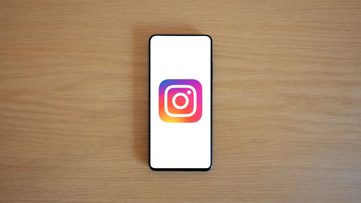 Ahşap masa üzerinde Instagram logosu açık bir akıllı telefon