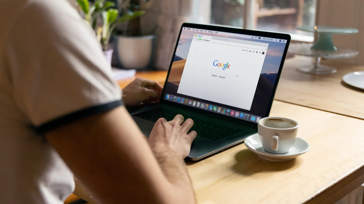 Google arama sayfası açık dizüstü bilgisayarı kullanan kişi