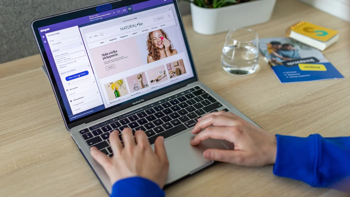 Dizüstü bilgisayarda e-ticaret mağazası tasarım panelini kullanan kişi