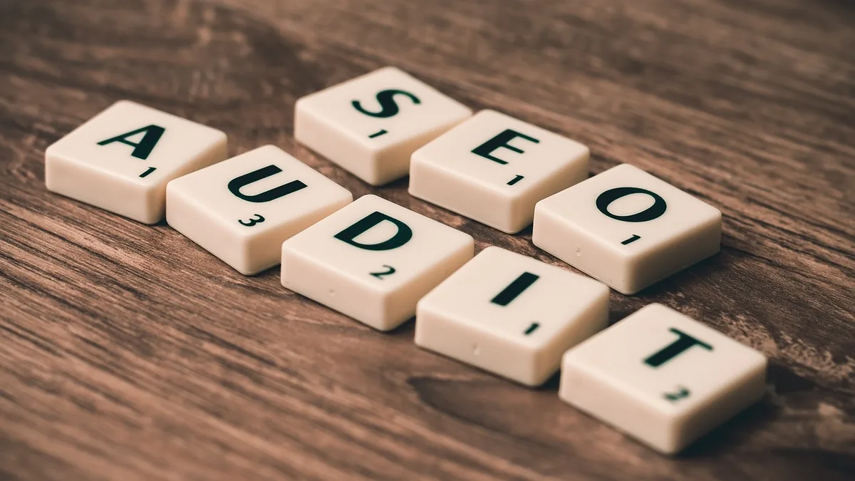 Ahşap harflerle SEO yazısı ve büyüteç bulunan masa