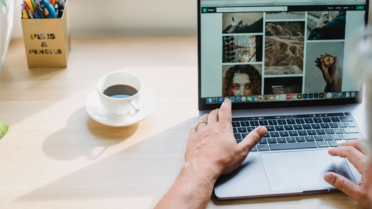 Dizüstü bilgisayarda web sayfasını kontrol eden kişi