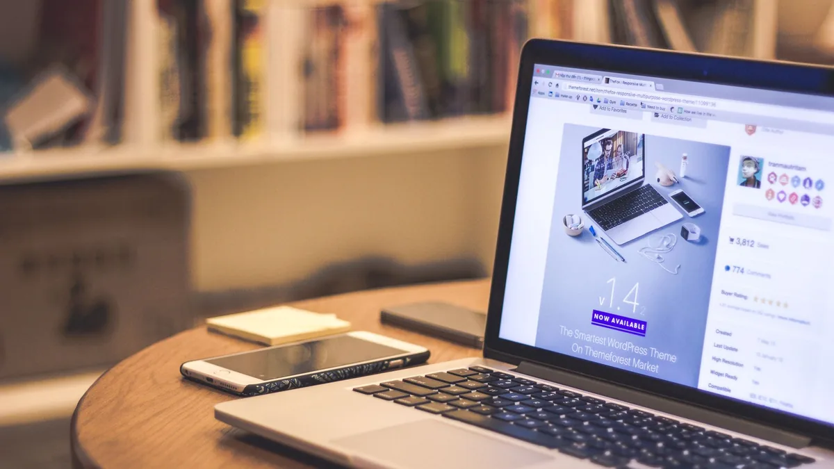 Web sitesi açık dizüstü bilgisayarın yanında akıllı telefon