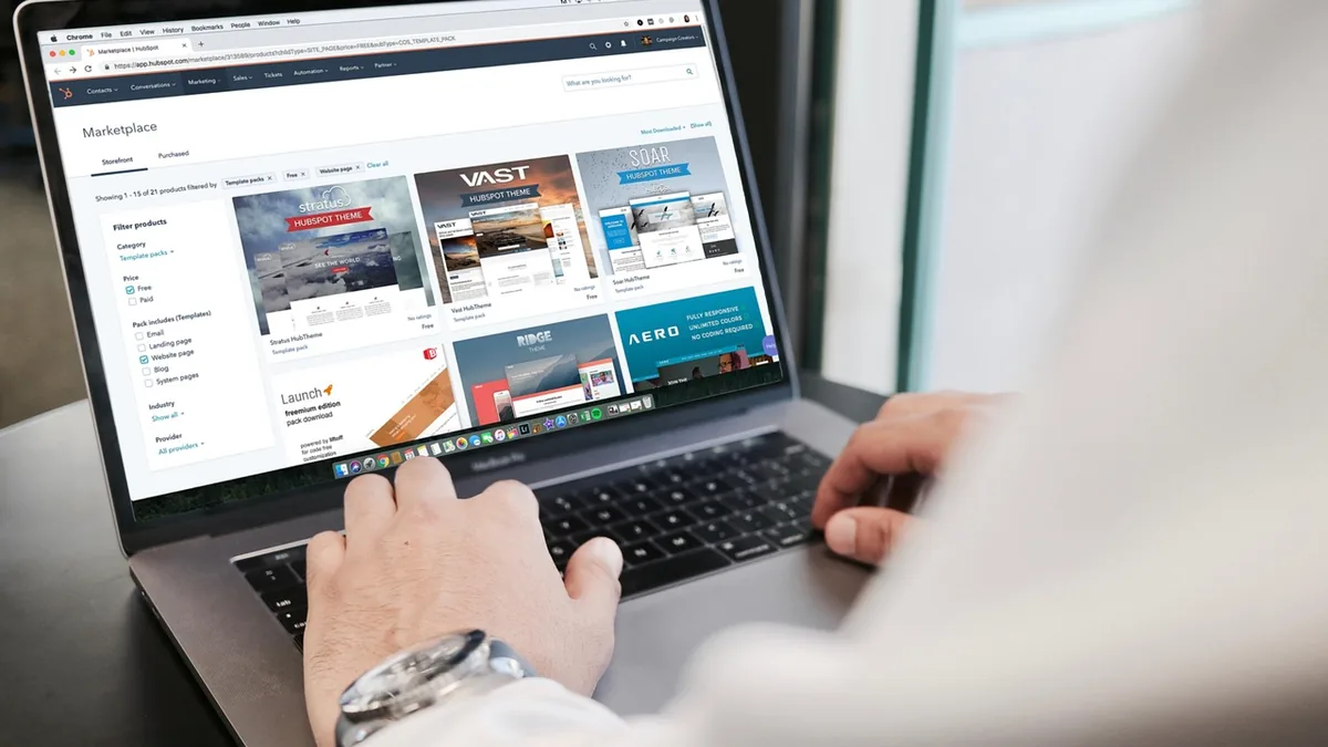 Web sitesi tasarımlarını dizüstü bilgisayarda inceleyen kişi