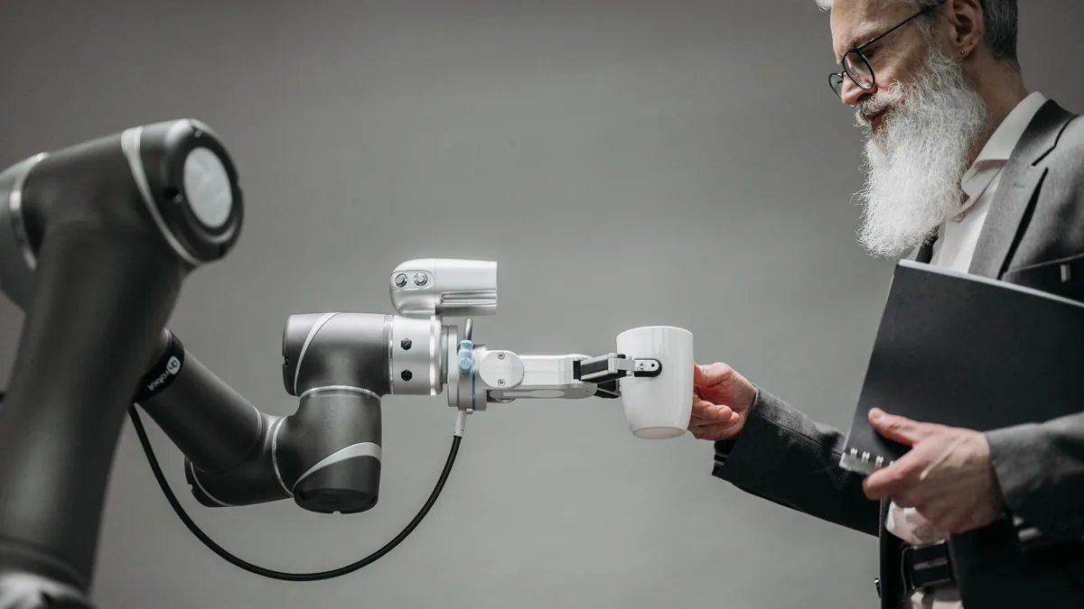 Robotik kolu inceleyen tabletli bir kişi