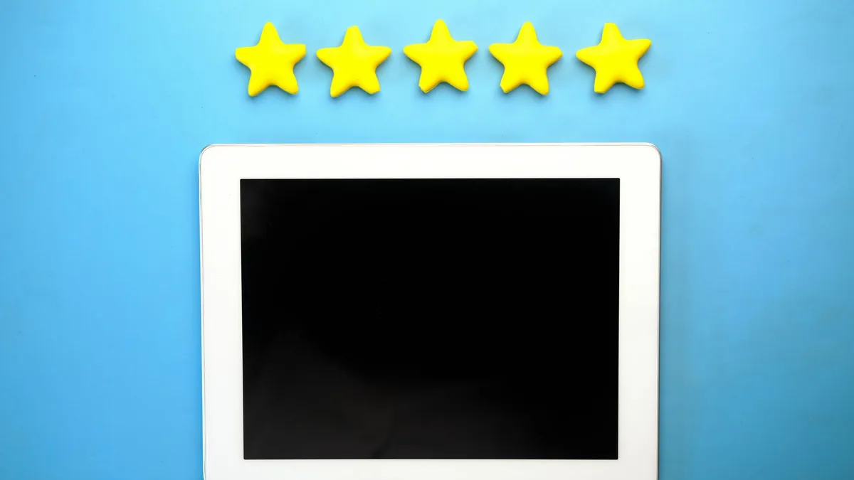 Beş sarı yıldızın altında duran boş ekranlı tablet
