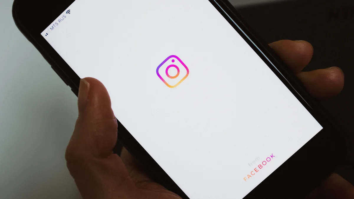 Instagram uygulamasını açan bir kişinin elindeki akıllı telefon